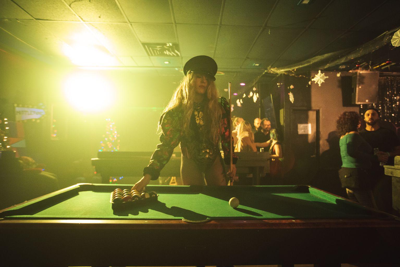 A woman with a party hat sets up a rack for pool