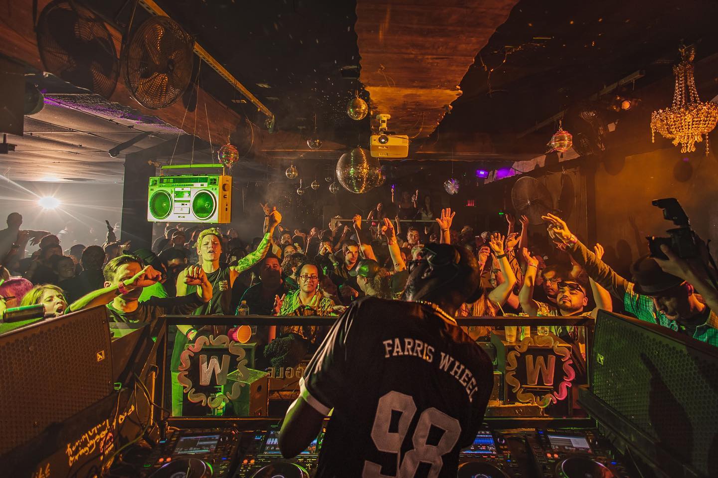 DJ Gene Farris facing crowd with hands up