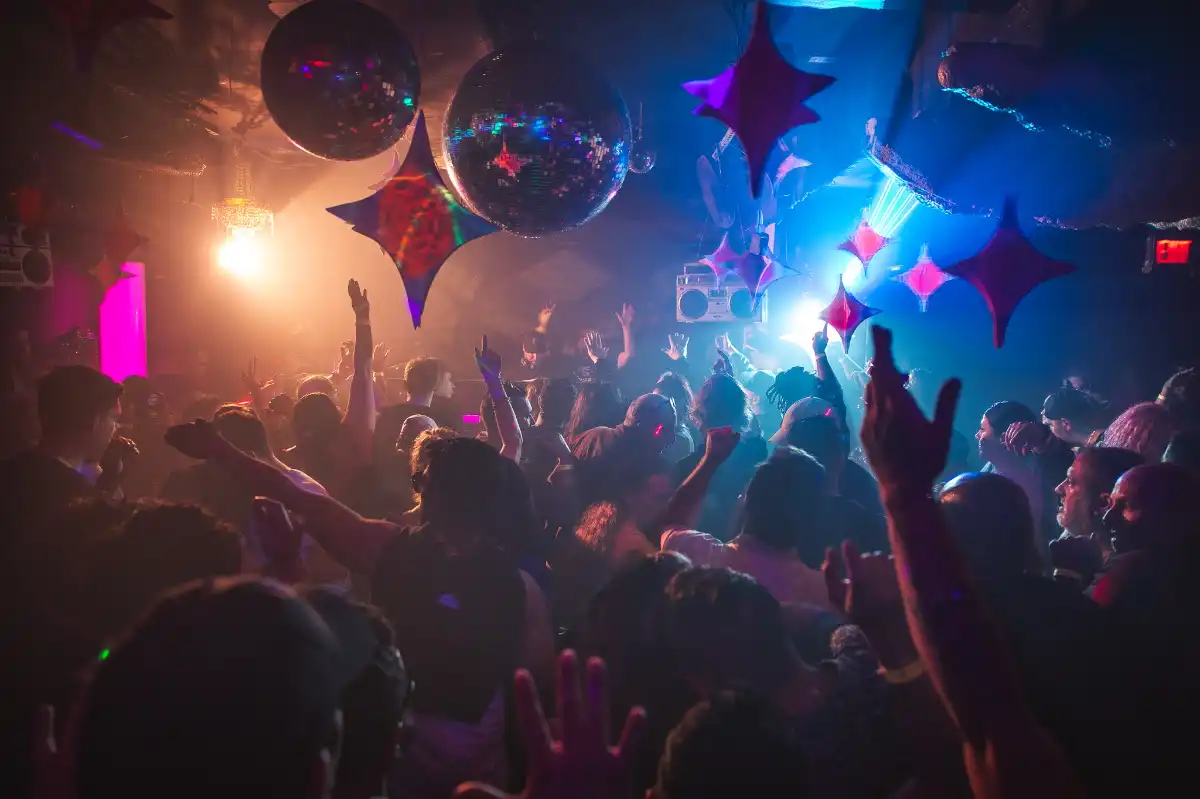 A crowd dancing with hands in the air