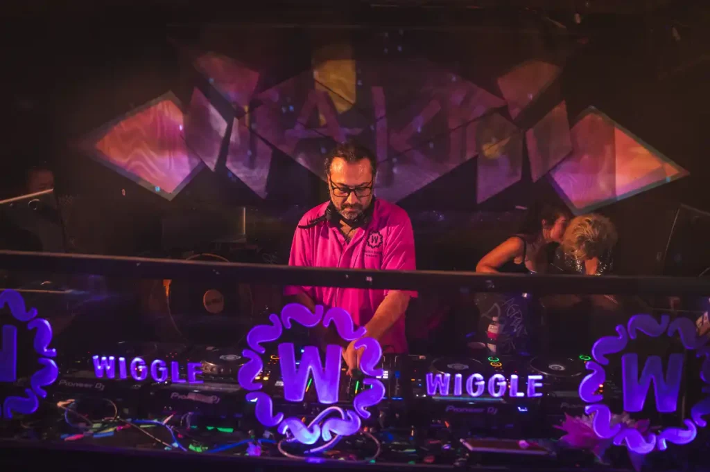A man DJing with a pink shirt