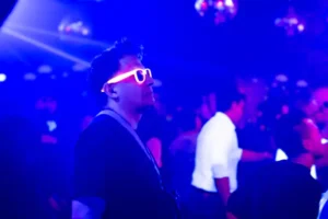 Man in sunglasses lit by neon light