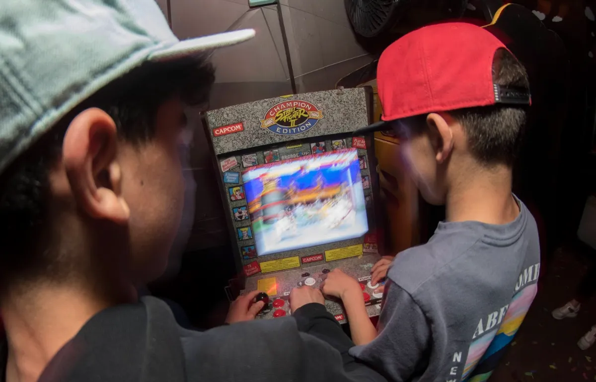 A young arcade game player and friend