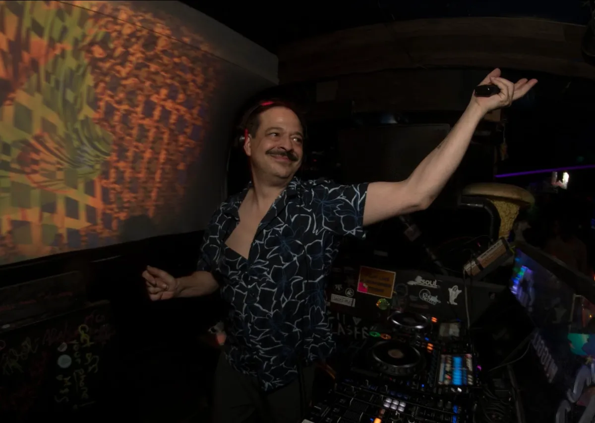 DJ with arm out up in the air