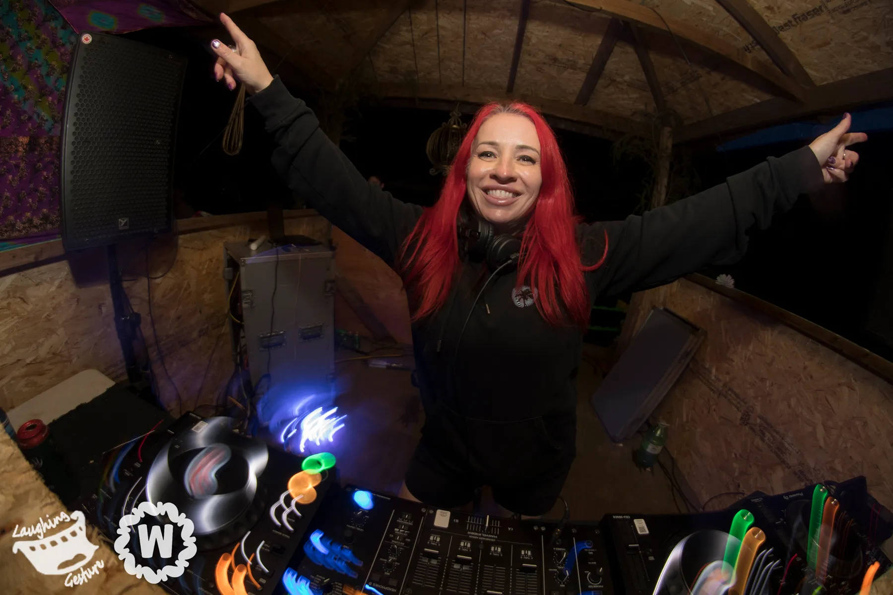 DJ with red hair at Camp Wiggly plays music, arms outstretched.