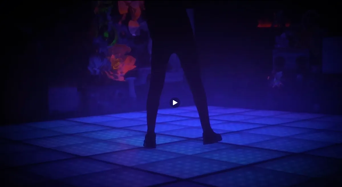 JELO & J.Elles perform on a glowing blue dance floor under purple lights.